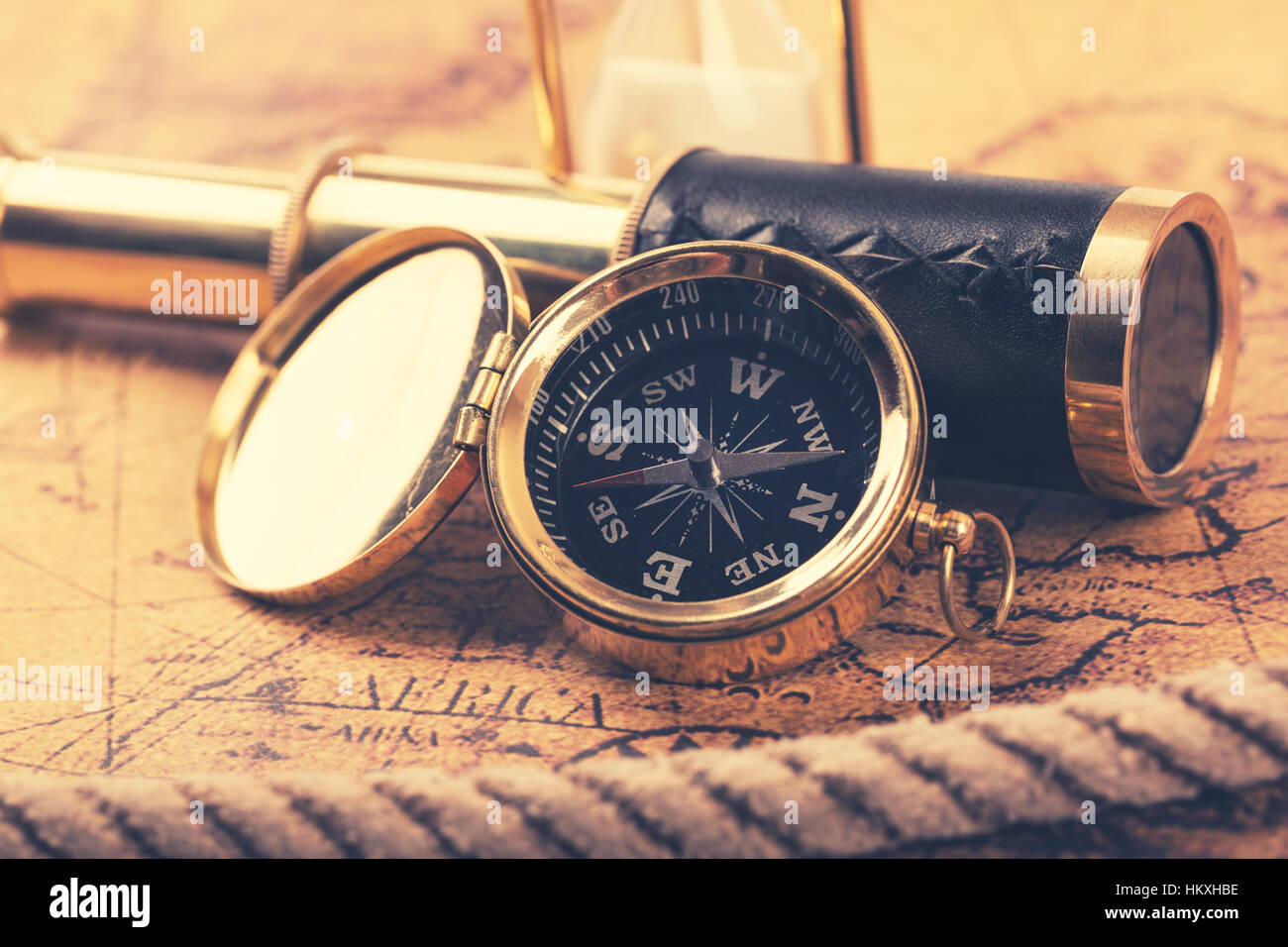 vintage compass and telescope on ancient world map Stock Photo