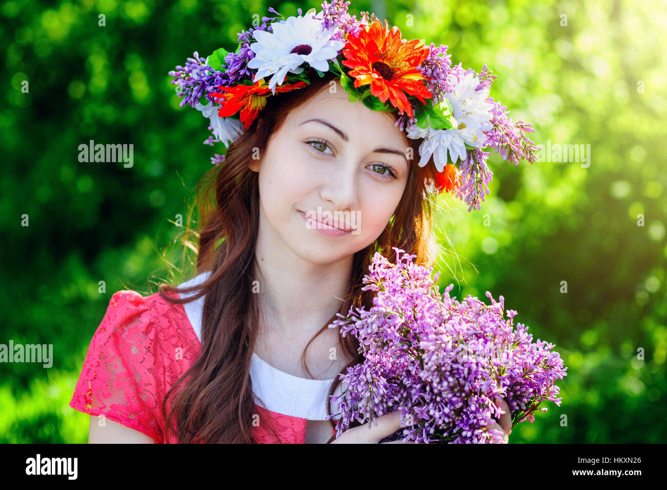 beautiful young woman with a wreath on his head and bouquet of lilacs Stock Photo