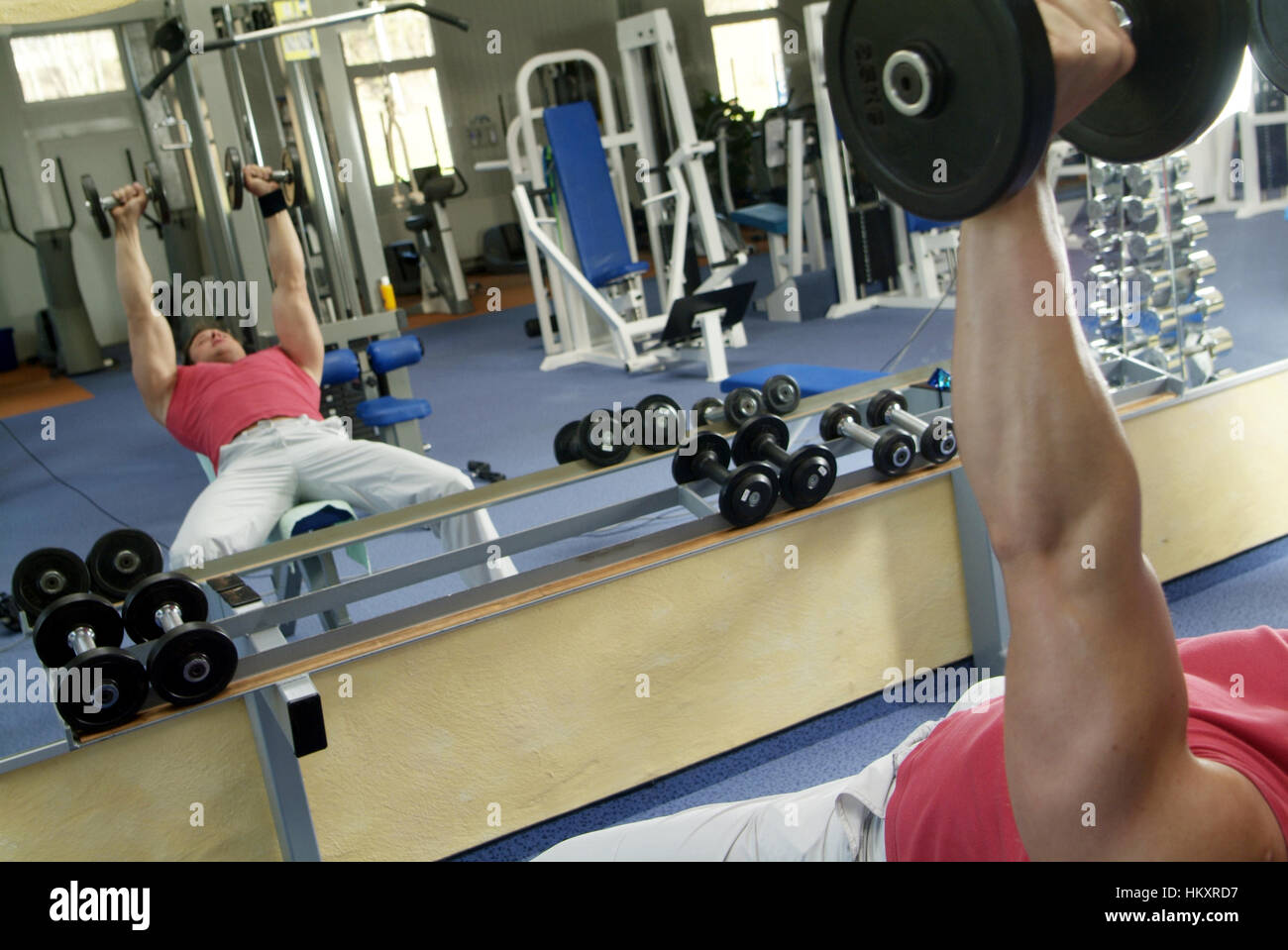 Young man does weight training in fitness center Stock Photo Alamy