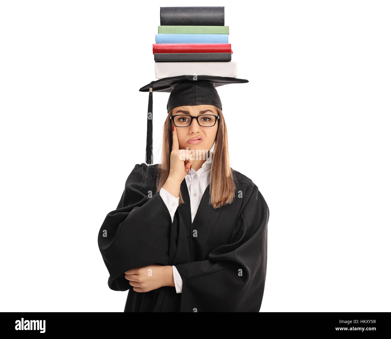 Upset graduate student with a stack of books on top of her head looking at the camera isolated on white background Stock Photo
