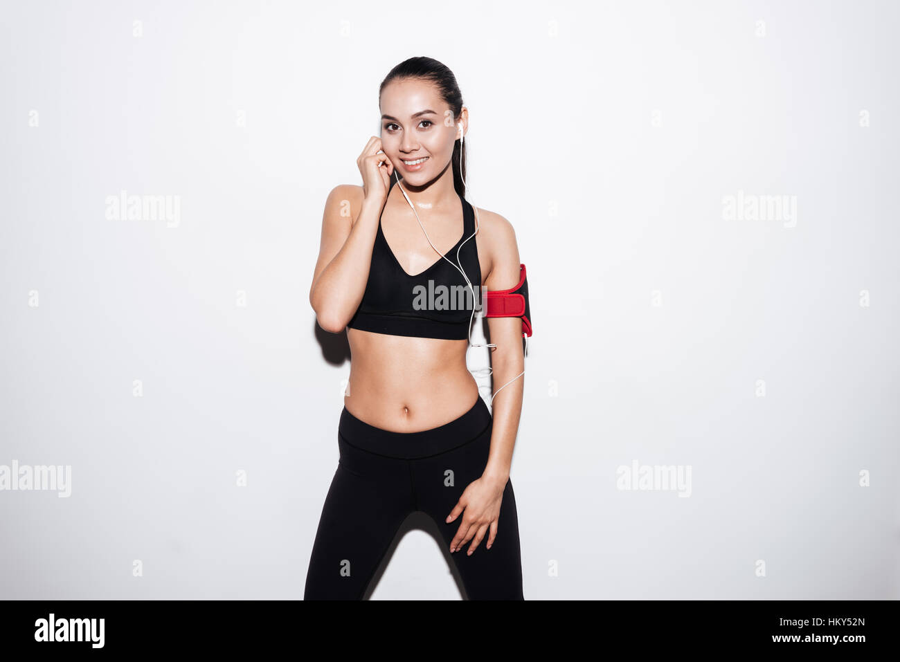 Fitness. Woman Doing Workout Exercise On Street. Beautiful Fit Girl Wearing  Fitness Tracker, Headphones And Armband Phone Case Stretching Her Long Legs  Outdoors. Sports Devices. High Resolution Stock Photo, Picture and Royalty