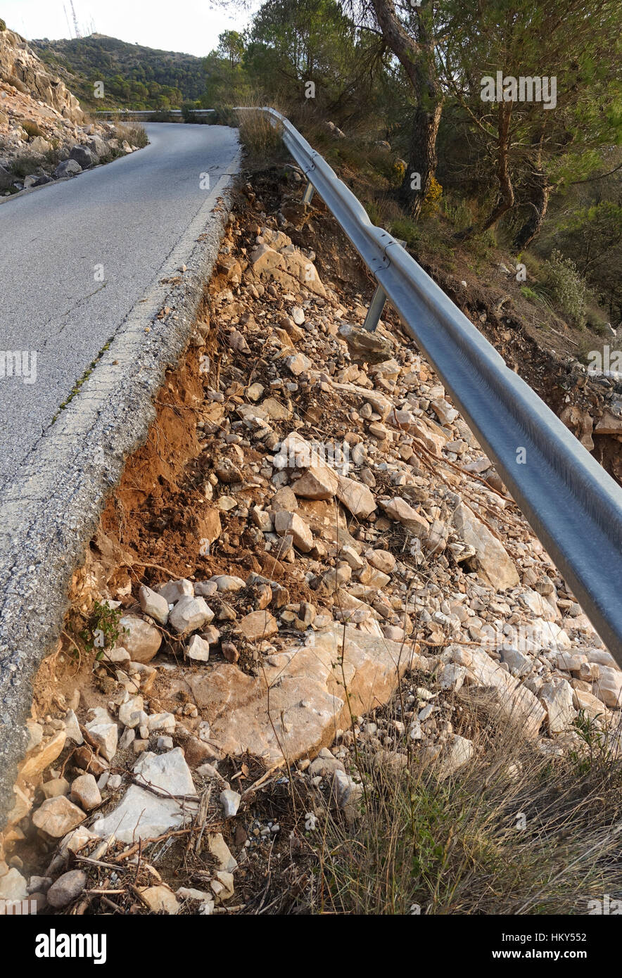 Road damage and loose Traffic barrier after heavy rainfall, Spain. Stock Photo