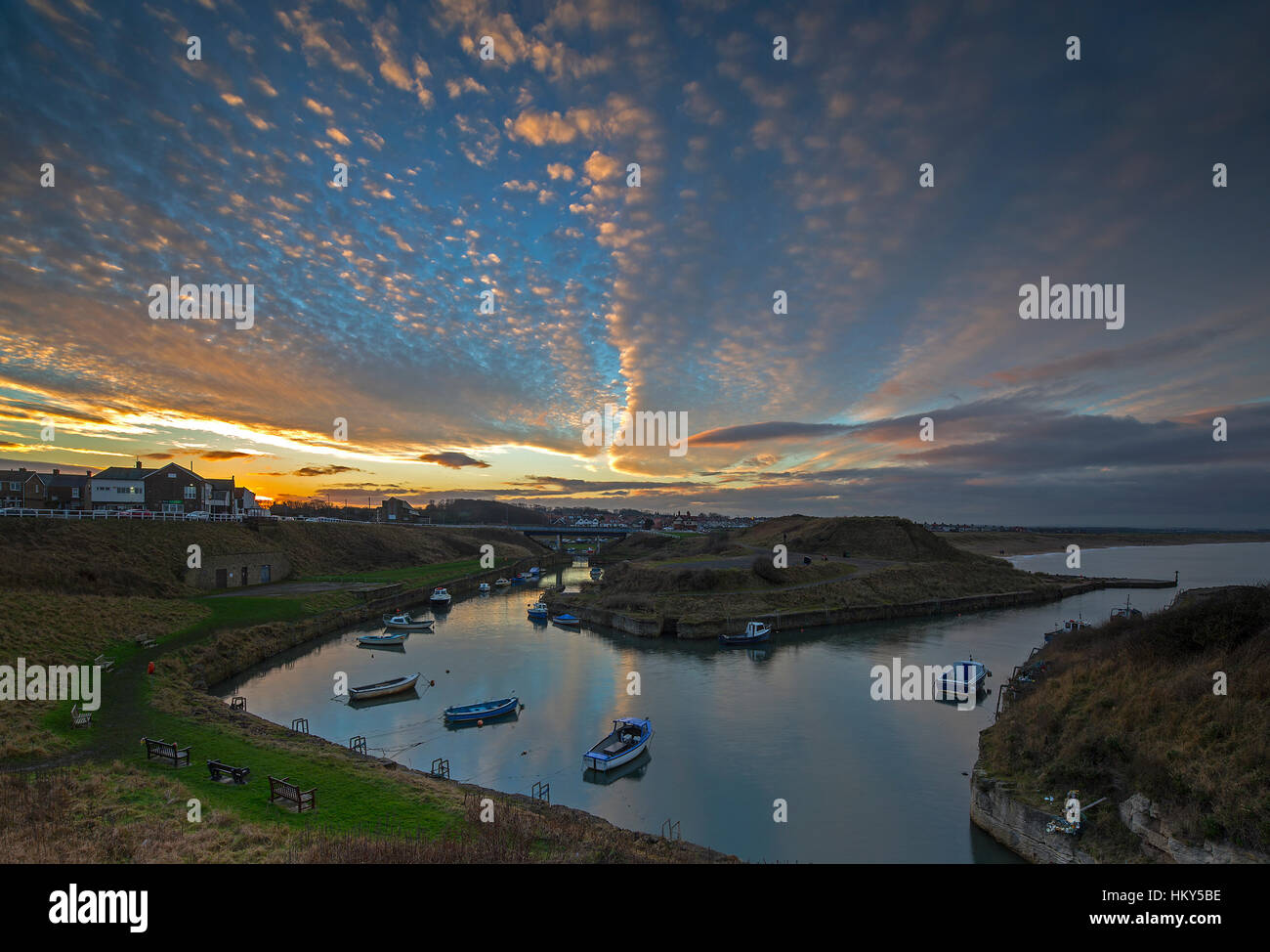 A vibrant sunset in winter over Seaton Sluice harbour looking towards Blyth, Northumberland, England, United Kingdom Stock Photo