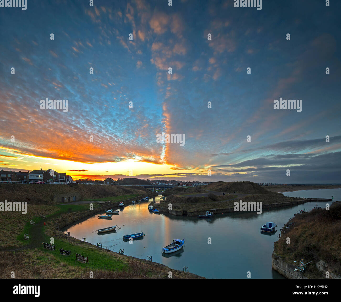 A vibrant sunset in winter over Seaton Sluice harbour looking towards Blyth, Northumberland, England, United Kingdom Stock Photo