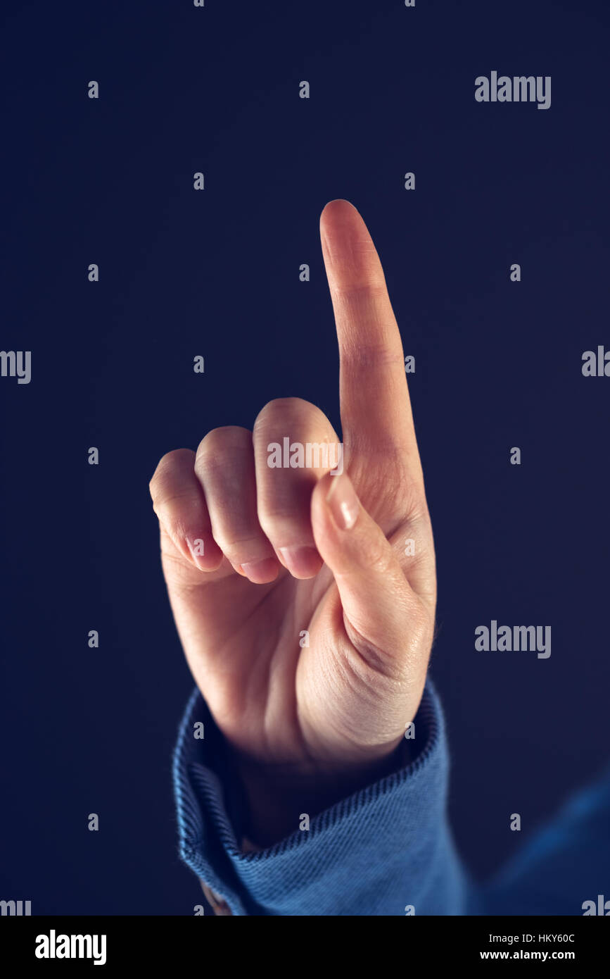 Businesswoman with raised index finger as if she is going to push virtual screen interface icon Stock Photo