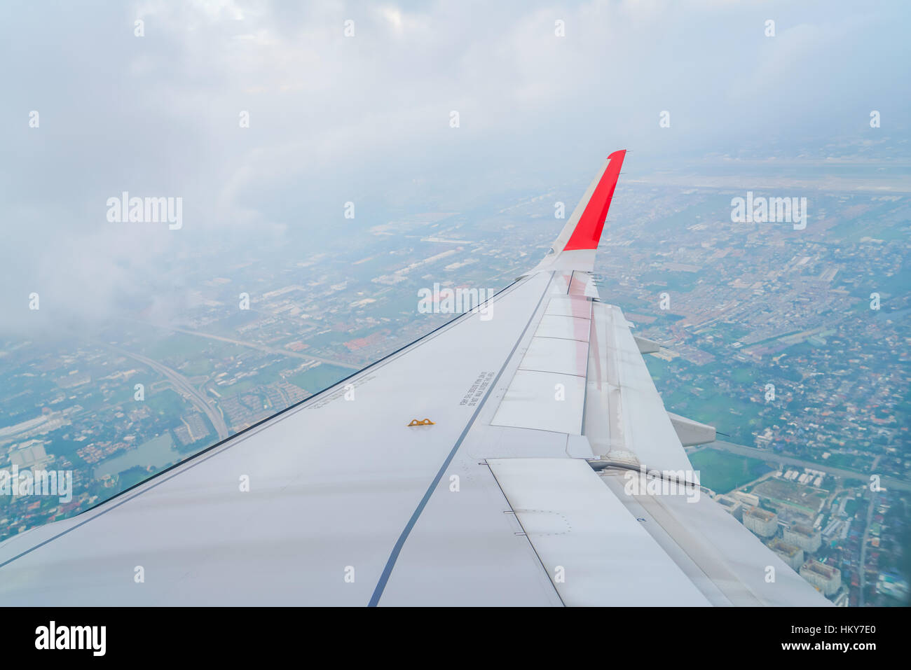Wing of an airplane flying above the clouds Stock Photo - Alamy
