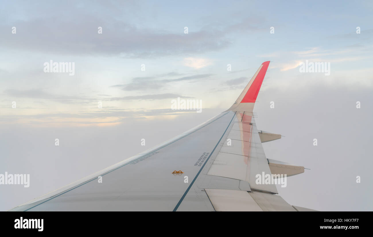 Wing of an airplane flying above the clouds Stock Photo - Alamy