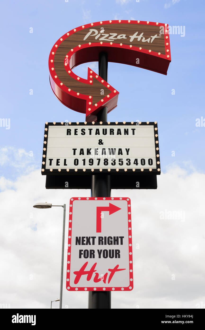 Retro style illuminated sign at Pizza Hut drive thru and restaurant in the United Kingdom Stock Photo