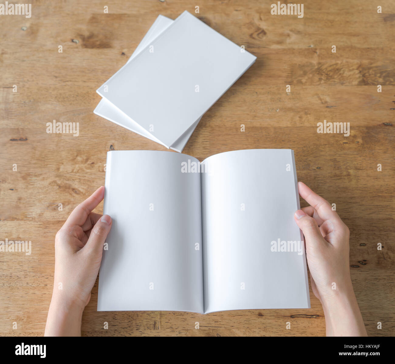 Hands open Blank catalog, magazines,book mock up on wood table Stock
