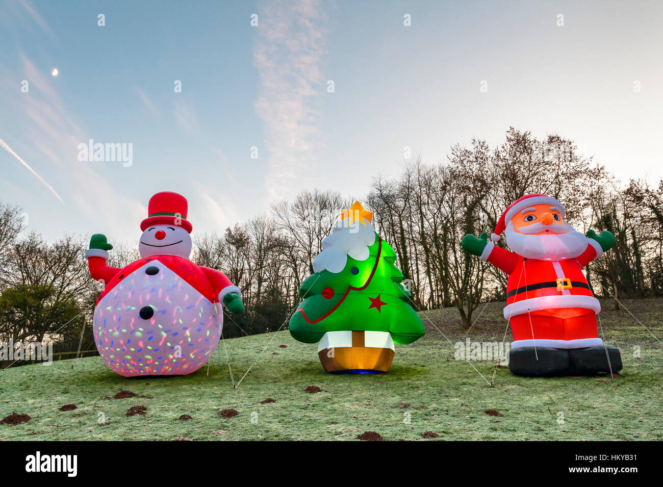 Huge illuminated inflatable Christmas figures stand in a frosty field