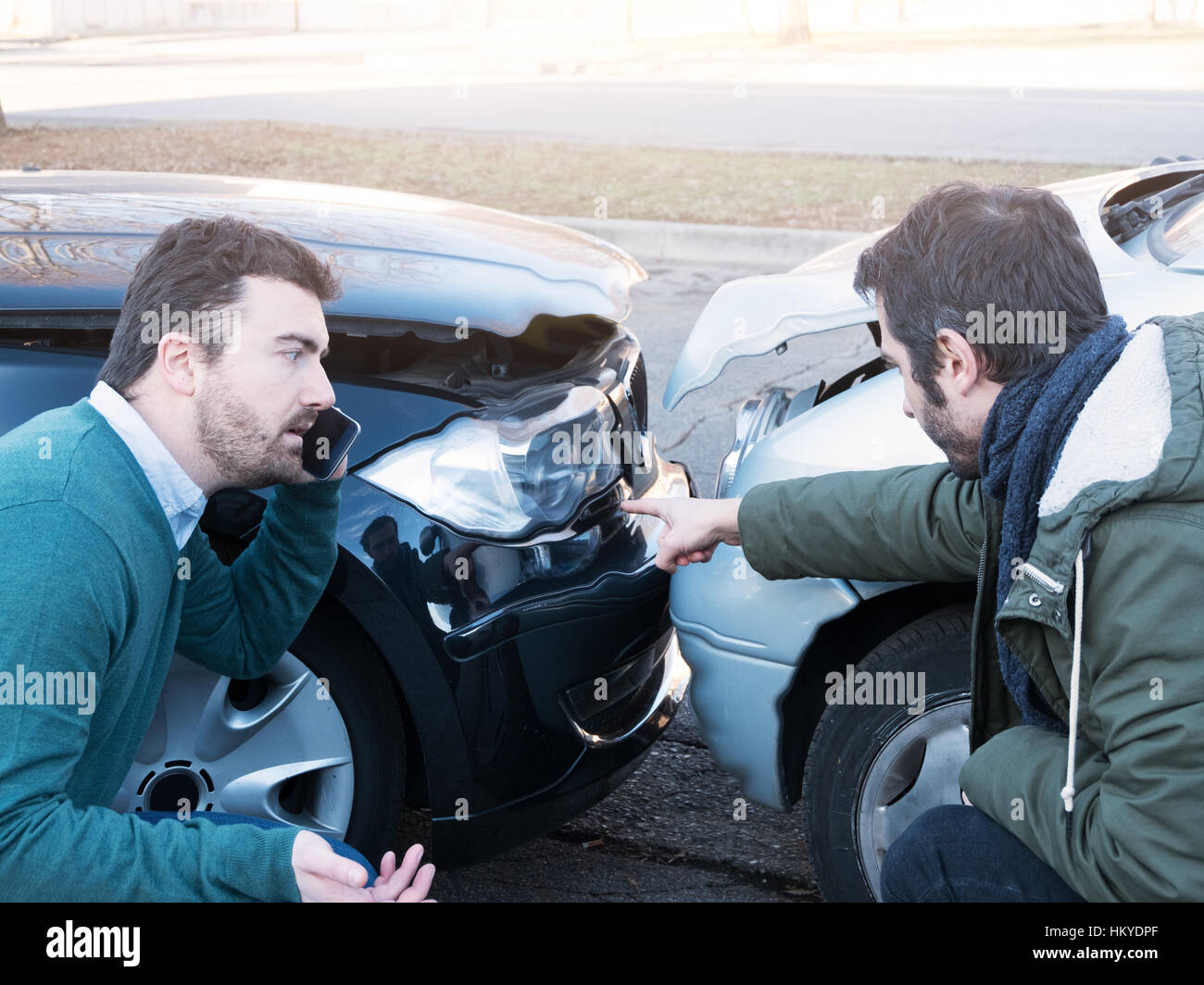 Two man arguing after a car accident on the street Stock Photo
