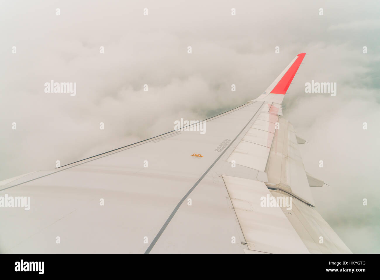 Wing of an airplane flying above the clouds Stock Photo - Alamy