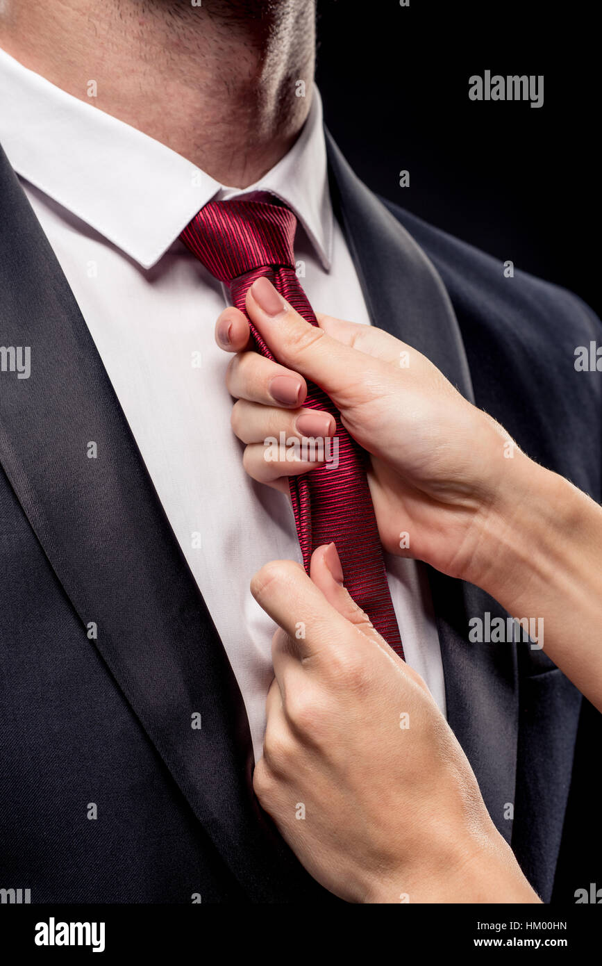 Woman holding businessman by tie Stock Photo