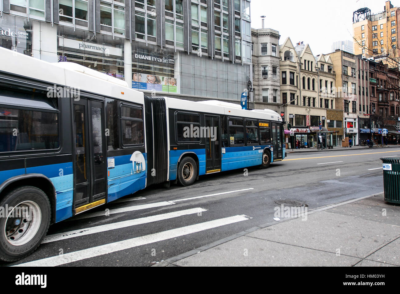 A long MTA bus is finishing making a turn onto 72 street on Manhattan's west side. Stock Photo