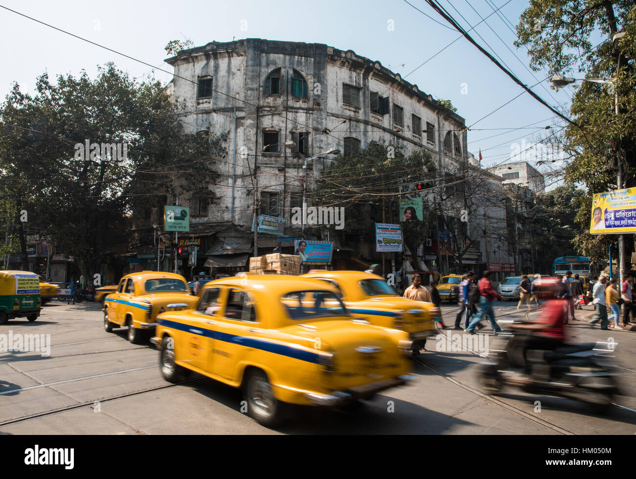 Yellow Ambassador taxis speed through a junction in Kolkata (Calcutta), West Bengal, India. Stock Photo