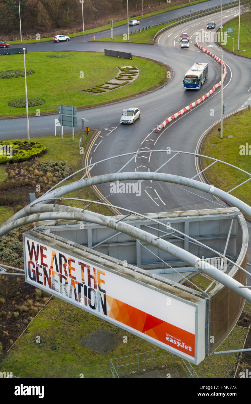 Vehicles travelling along roads on approach to Gatwick Airport for North and South terminals in January with We are the Generation EasyJet sign Stock Photo