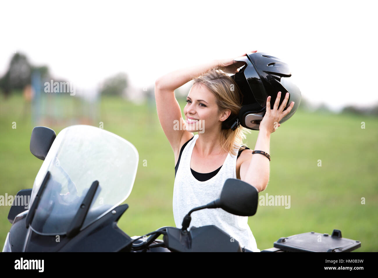 Pretty blond woman enjoying a quad bike ride in countryside. Stock Photo