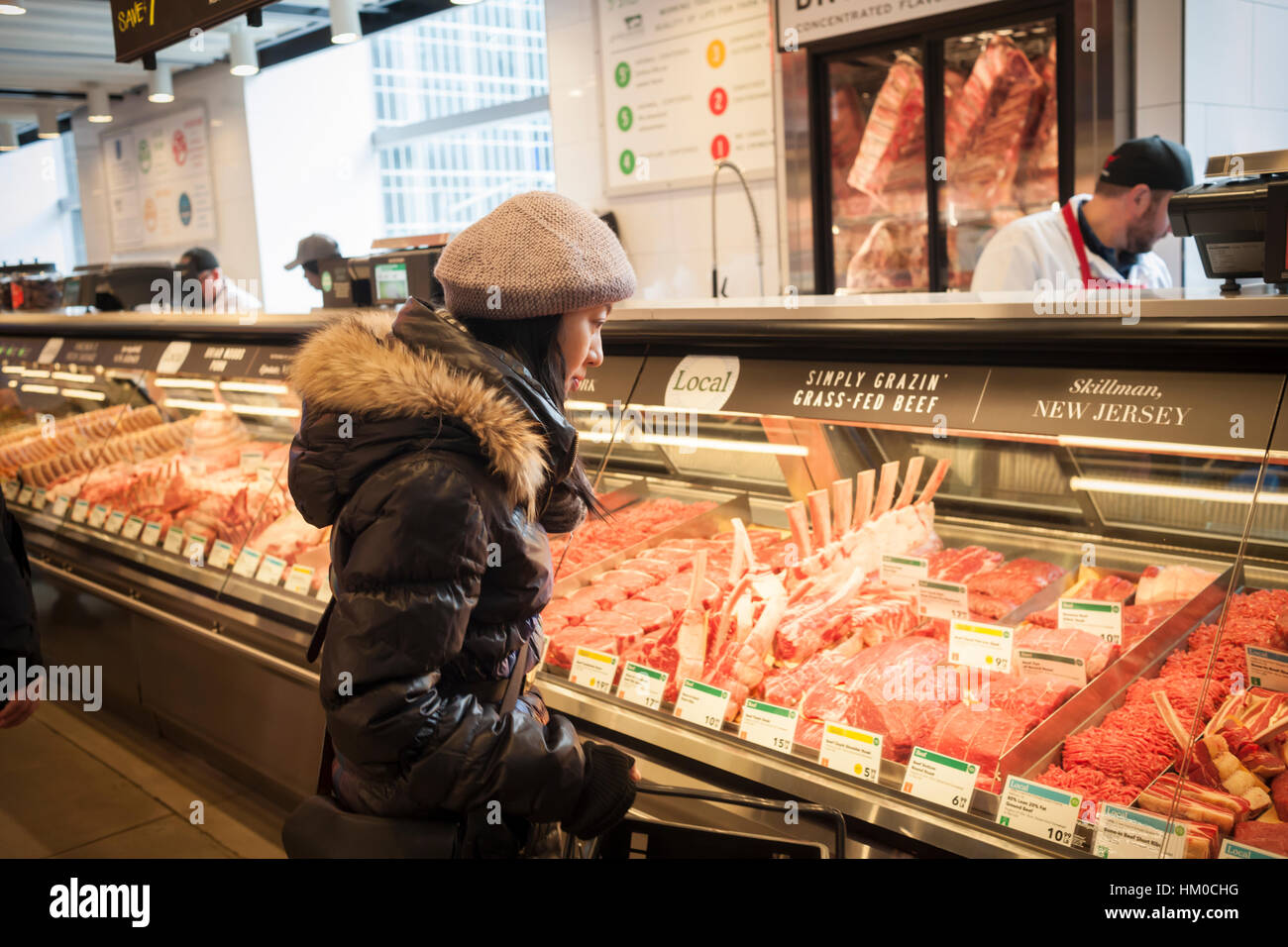 A shopper chooses cuts of meat in the new Whole Foods Market ...