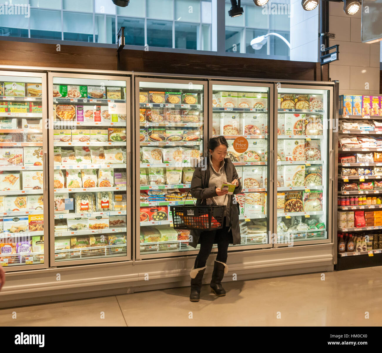 A shopper chooses cuts of meat in the new Whole Foods Market opposite  Bryant Park in New York on opening day Saturday, January 28, 2017. The  store in Midtown Manhattan is the