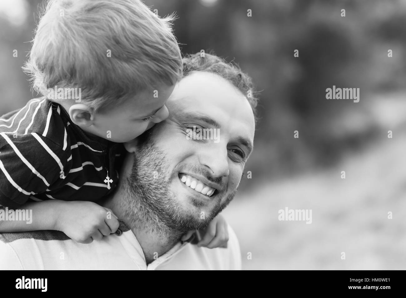 Child playing with his father. Daddy playing active games with his son outside. Happy family portrait. Laughing dad with little boy enjoying nature to Stock Photo