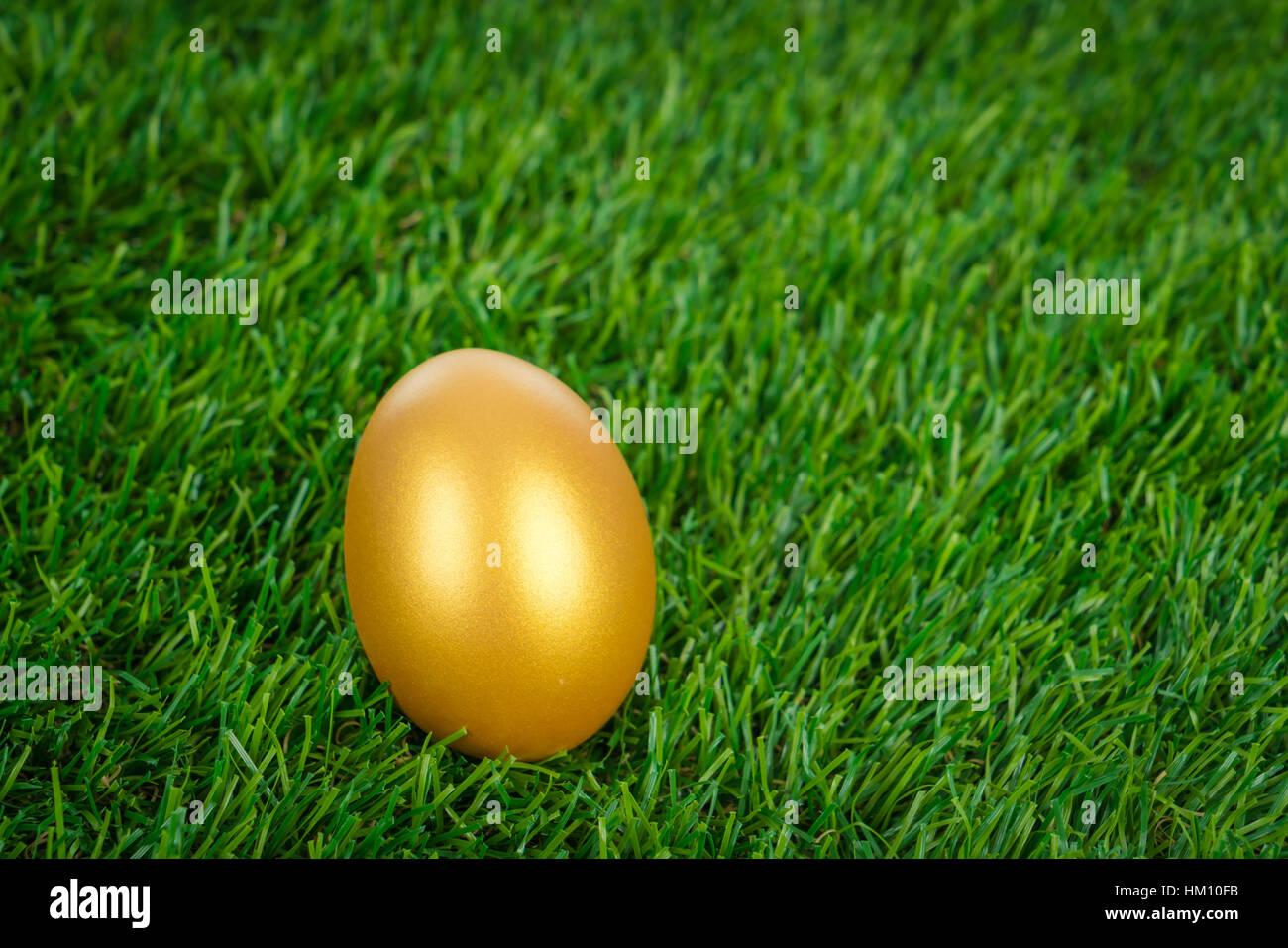 Gold easter egg on a green grass Stock Photo - Alamy