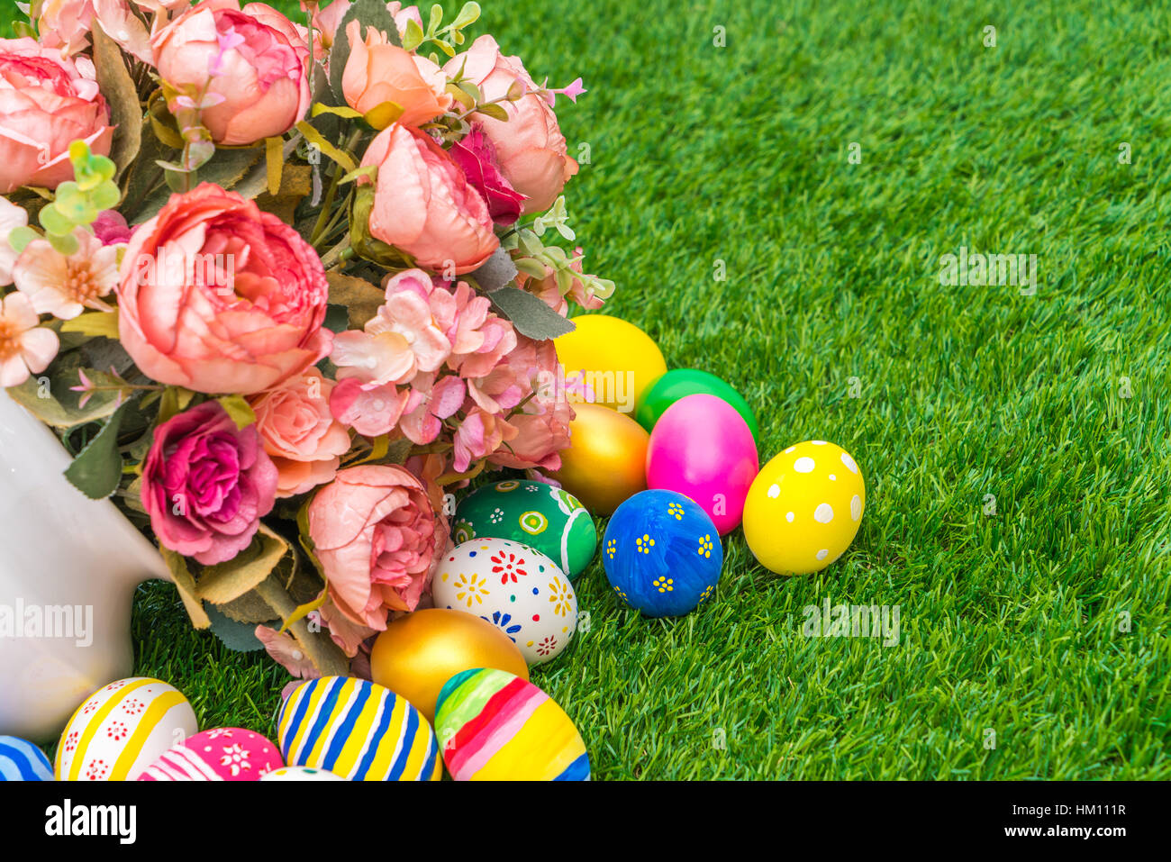 Easter eggs with artificial flower on Fresh Green Grass Stock Photo - Alamy