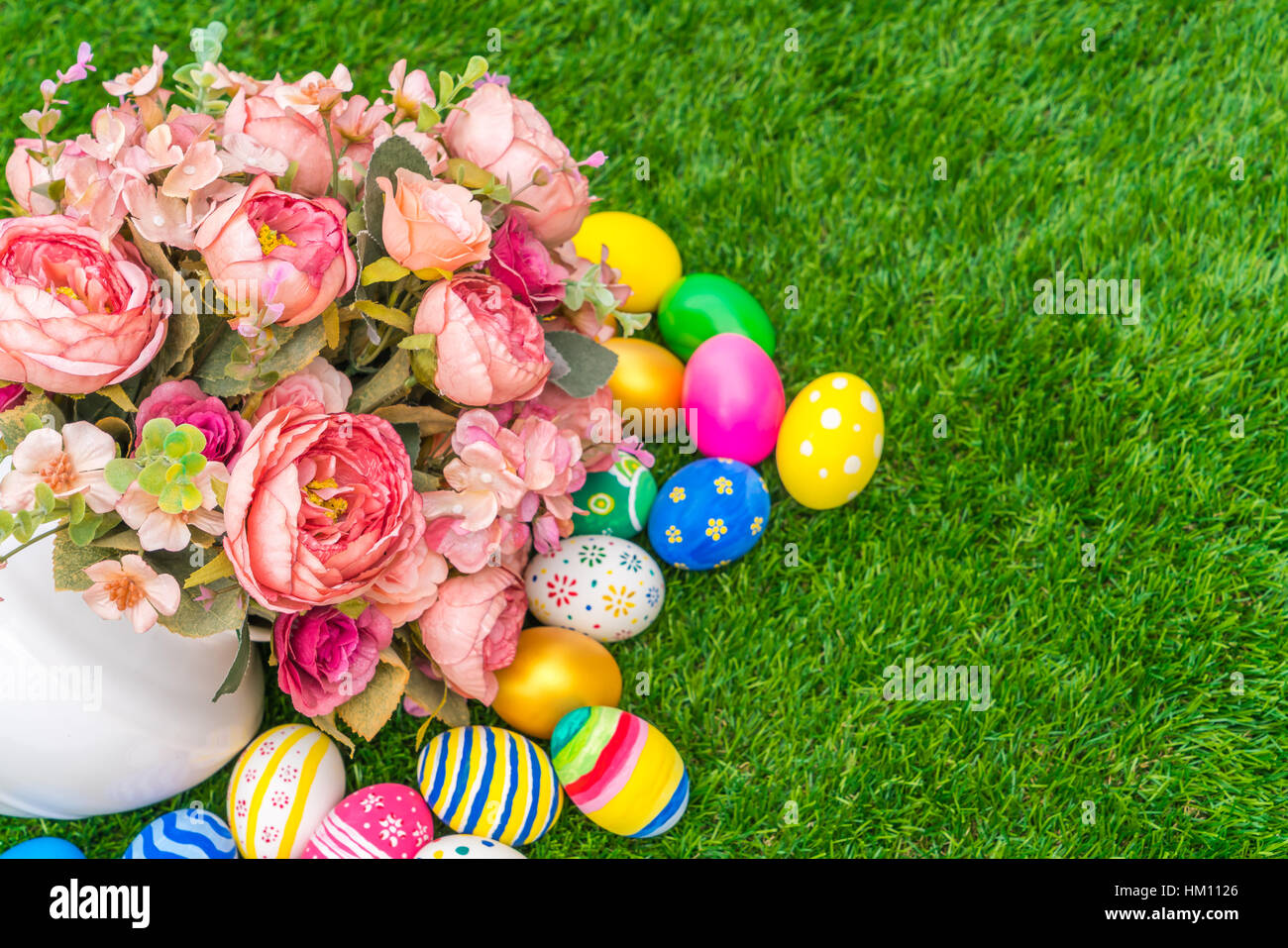Easter eggs with artificial flower on Fresh Green Grass Stock Photo - Alamy