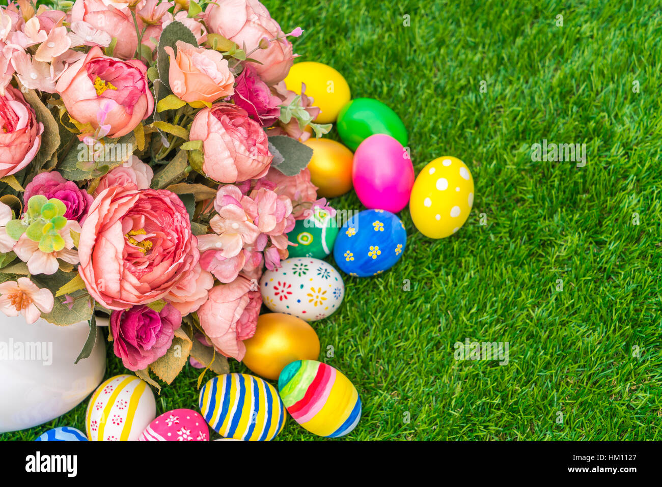 Easter eggs with artificial flower on Fresh Green Grass Stock Photo - Alamy