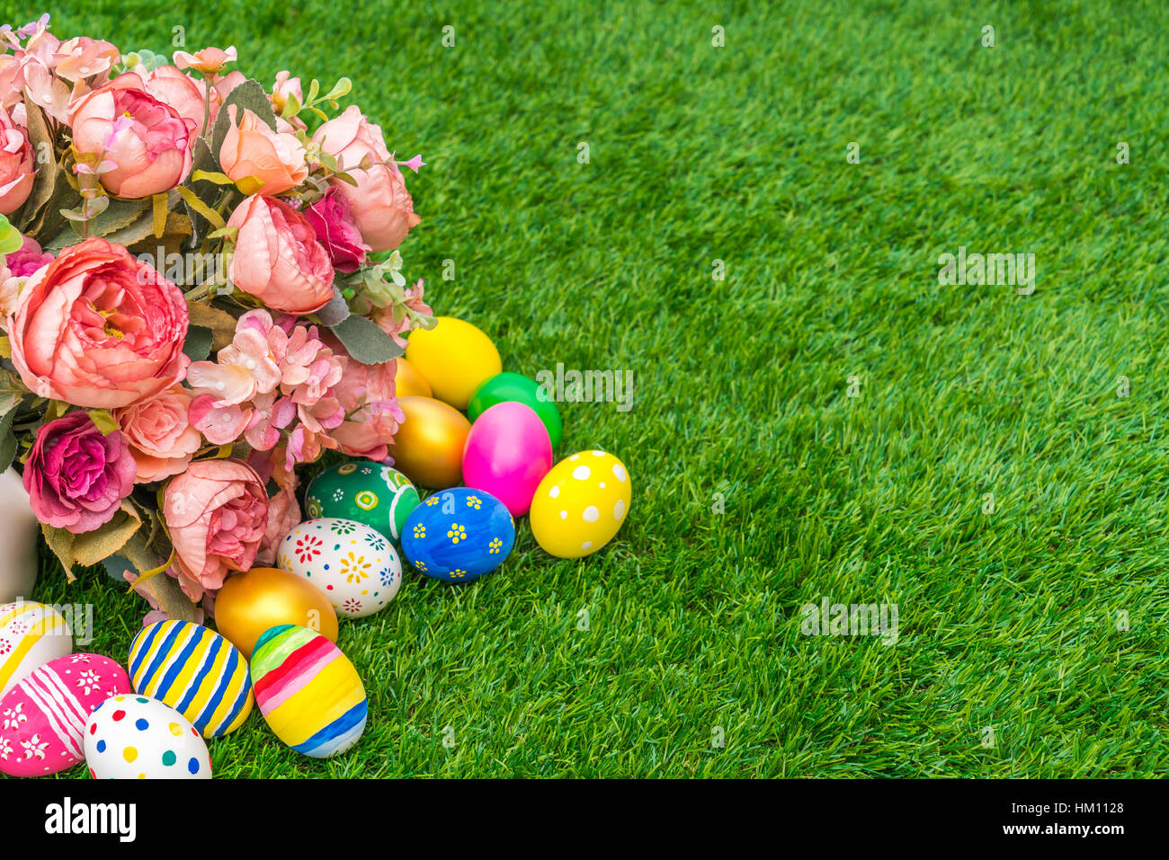 Easter eggs with artificial flower on Fresh Green Grass Stock Photo - Alamy