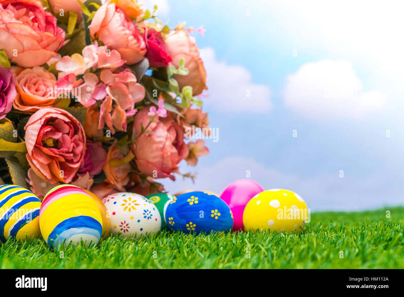 Easter eggs with artificial flower on Fresh Green Grass Stock Photo - Alamy