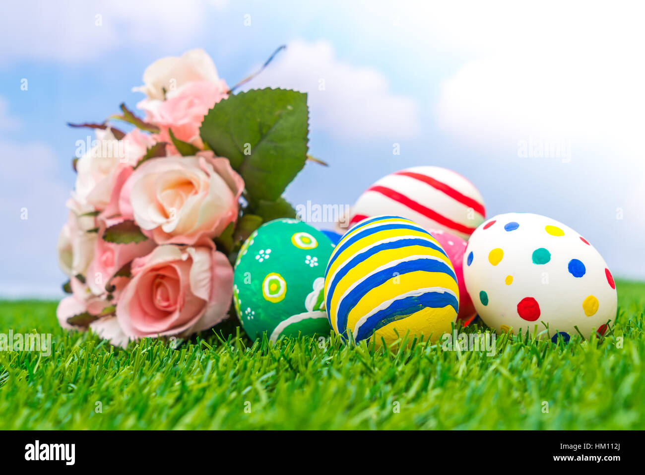 Easter eggs with artificial flower on Fresh Green Grass Stock Photo - Alamy