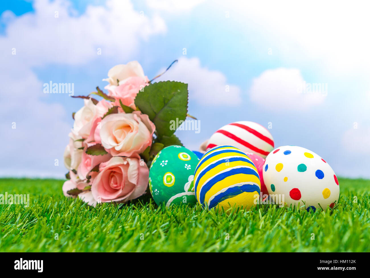 Easter eggs with artificial flower on Fresh Green Grass Stock Photo - Alamy