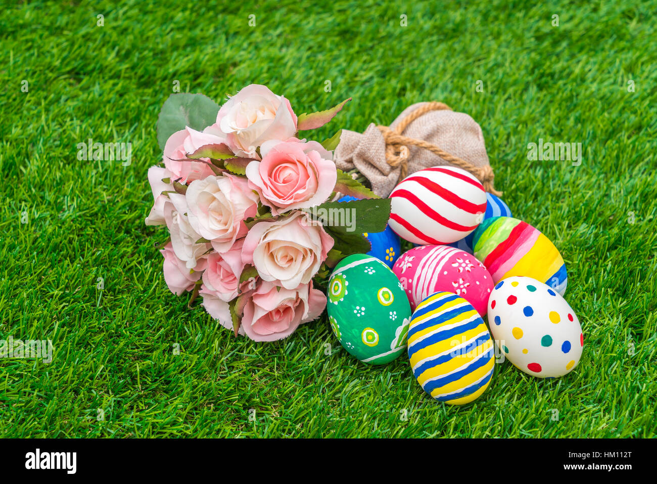 Easter eggs with artificial flower on Fresh Green Grass Stock Photo - Alamy