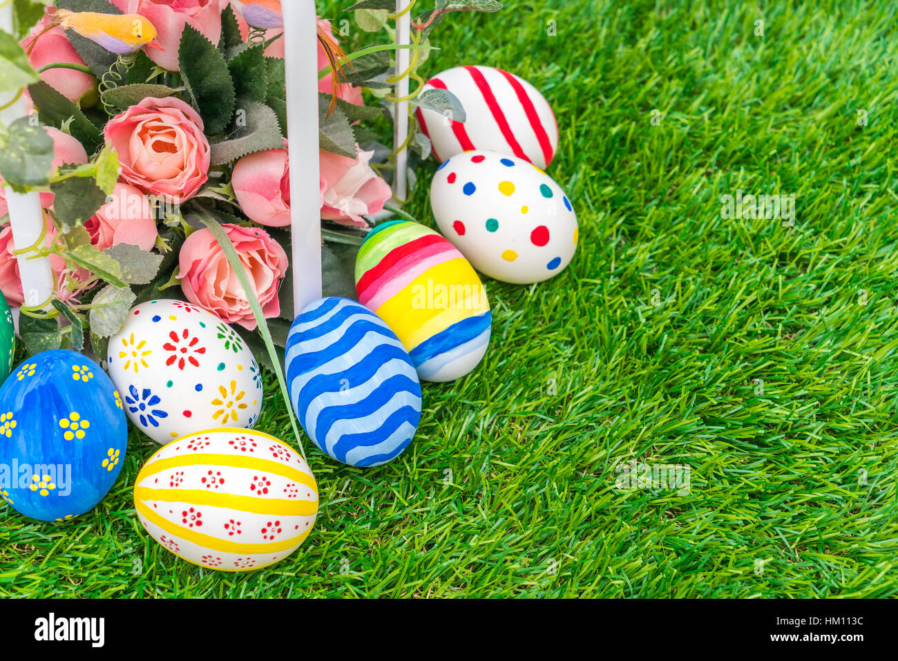 Easter eggs with artificial flower on Fresh Green Grass Stock Photo - Alamy