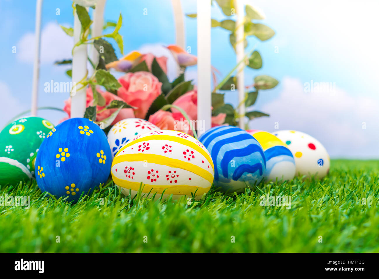 Easter eggs with artificial flower on Fresh Green Grass Stock Photo - Alamy