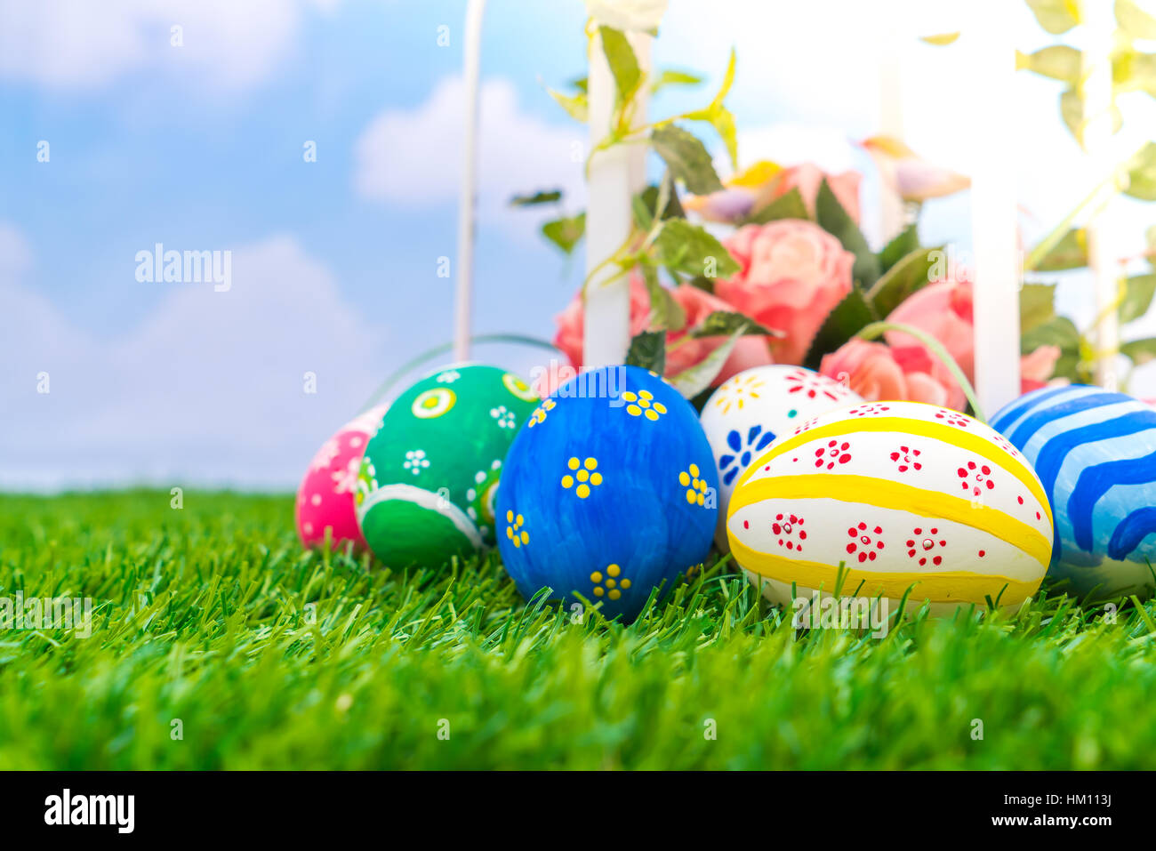 Easter eggs with artificial flower on Fresh Green Grass Stock Photo - Alamy