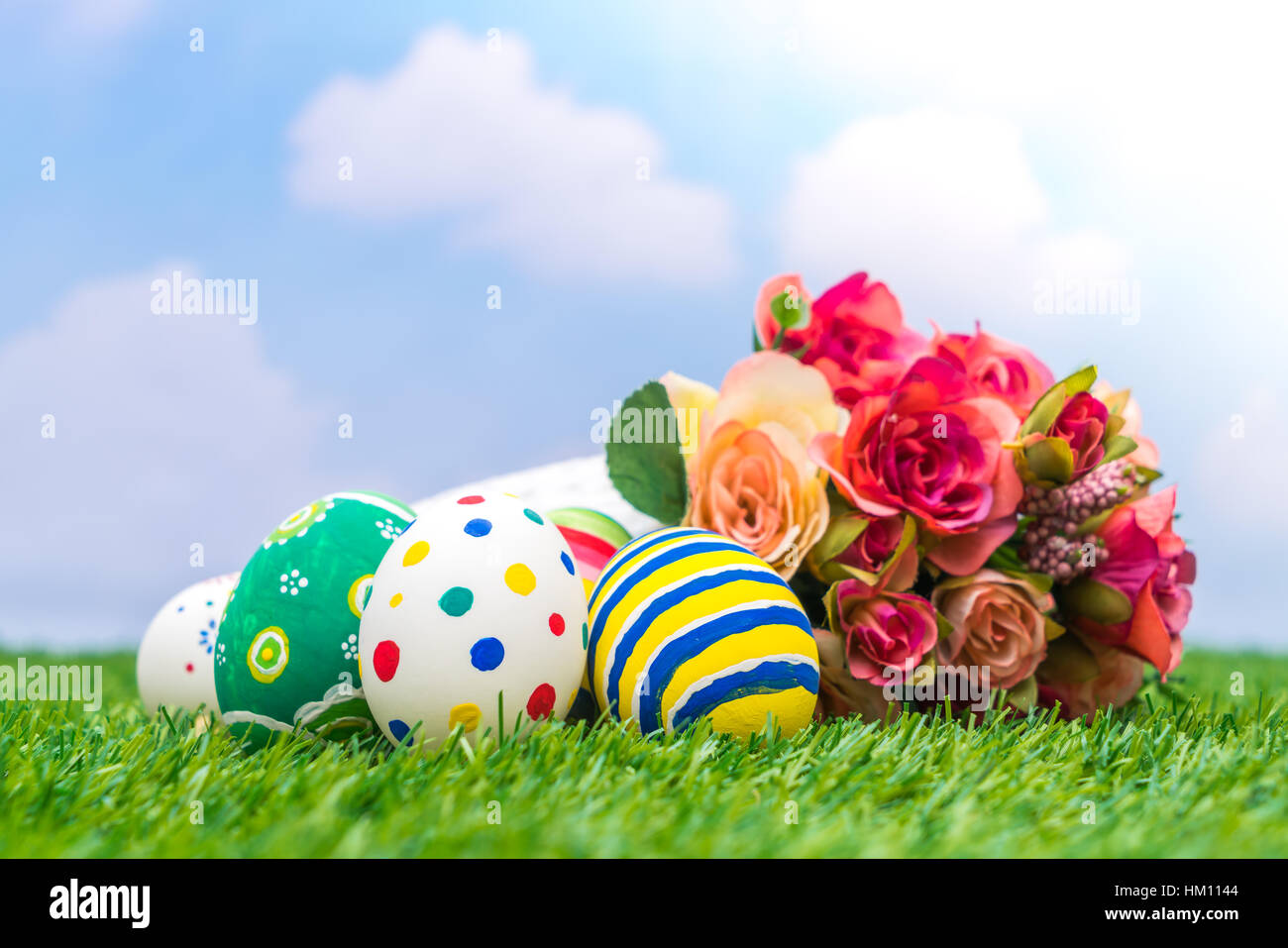Easter eggs with artificial flower on Fresh Green Grass Stock Photo - Alamy