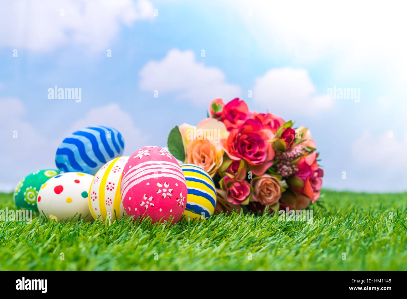 Easter eggs with artificial flower on Fresh Green Grass Stock Photo - Alamy