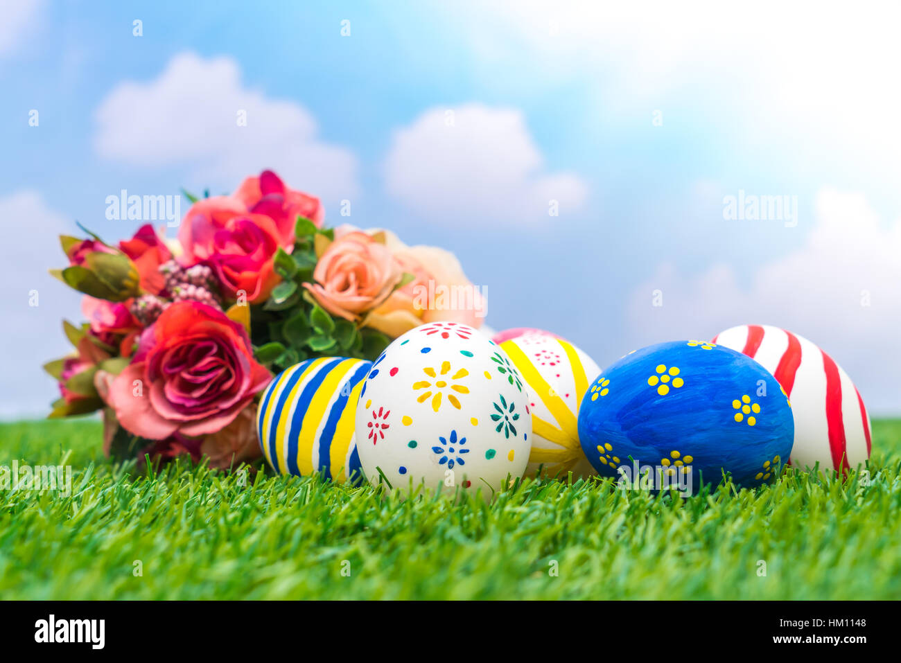 Easter eggs with artificial flower on Fresh Green Grass Stock Photo - Alamy