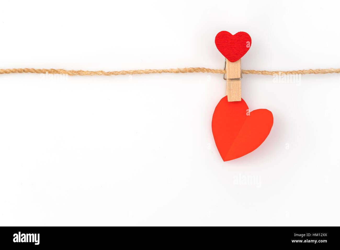 Red paper heart hanging on white background Stock Photo - Alamy