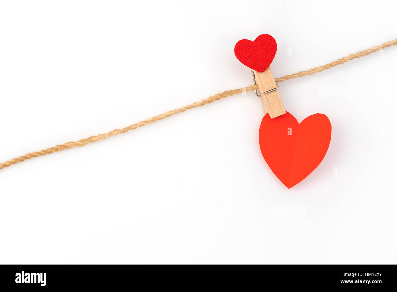 Red paper heart hanging on white background Stock Photo - Alamy