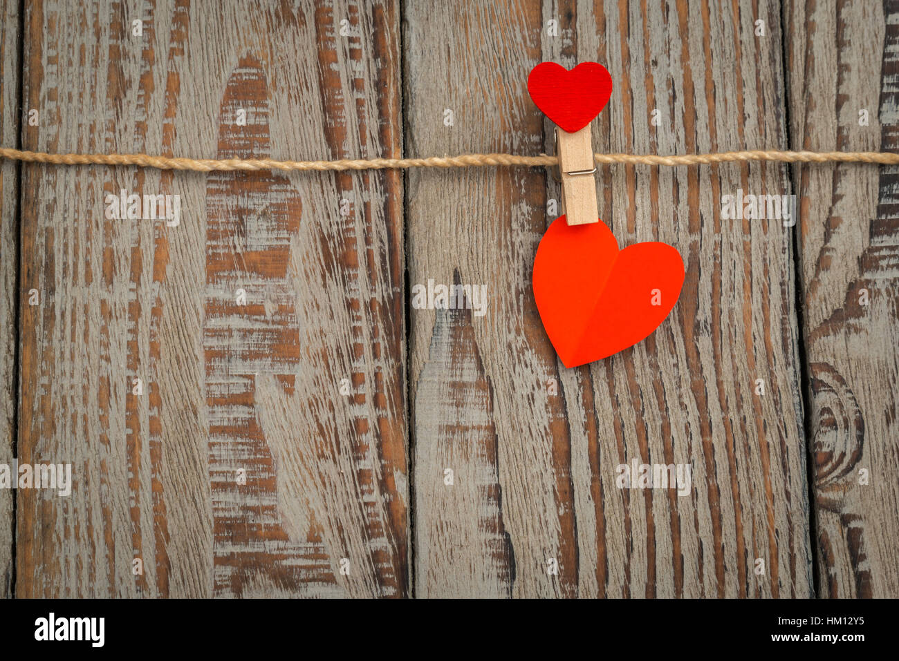 Red paper heart hanging on wood background Stock Photo - Alamy