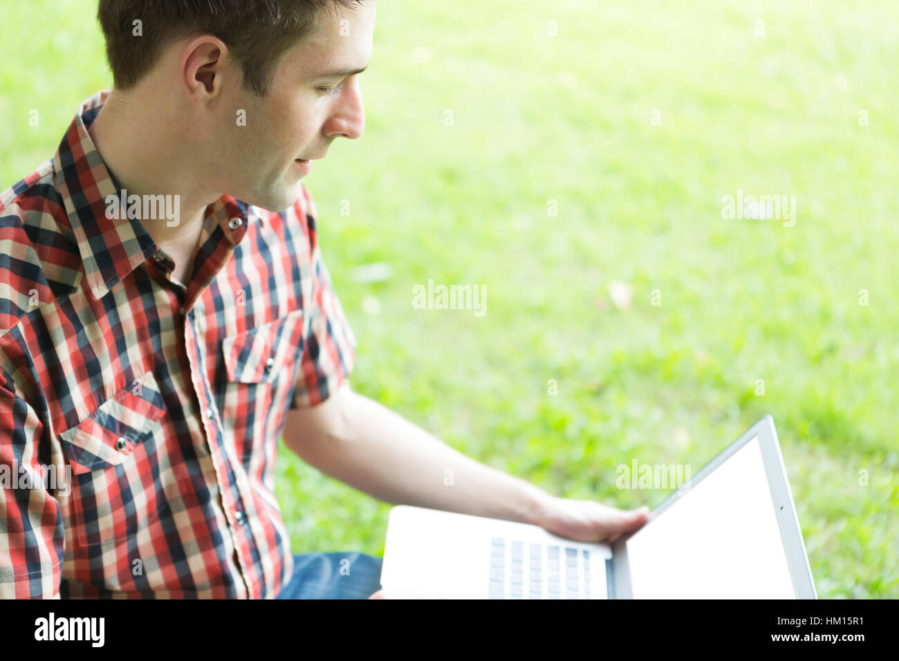 Portrait of young man with laptop outdoor Stock Photo - Alamy