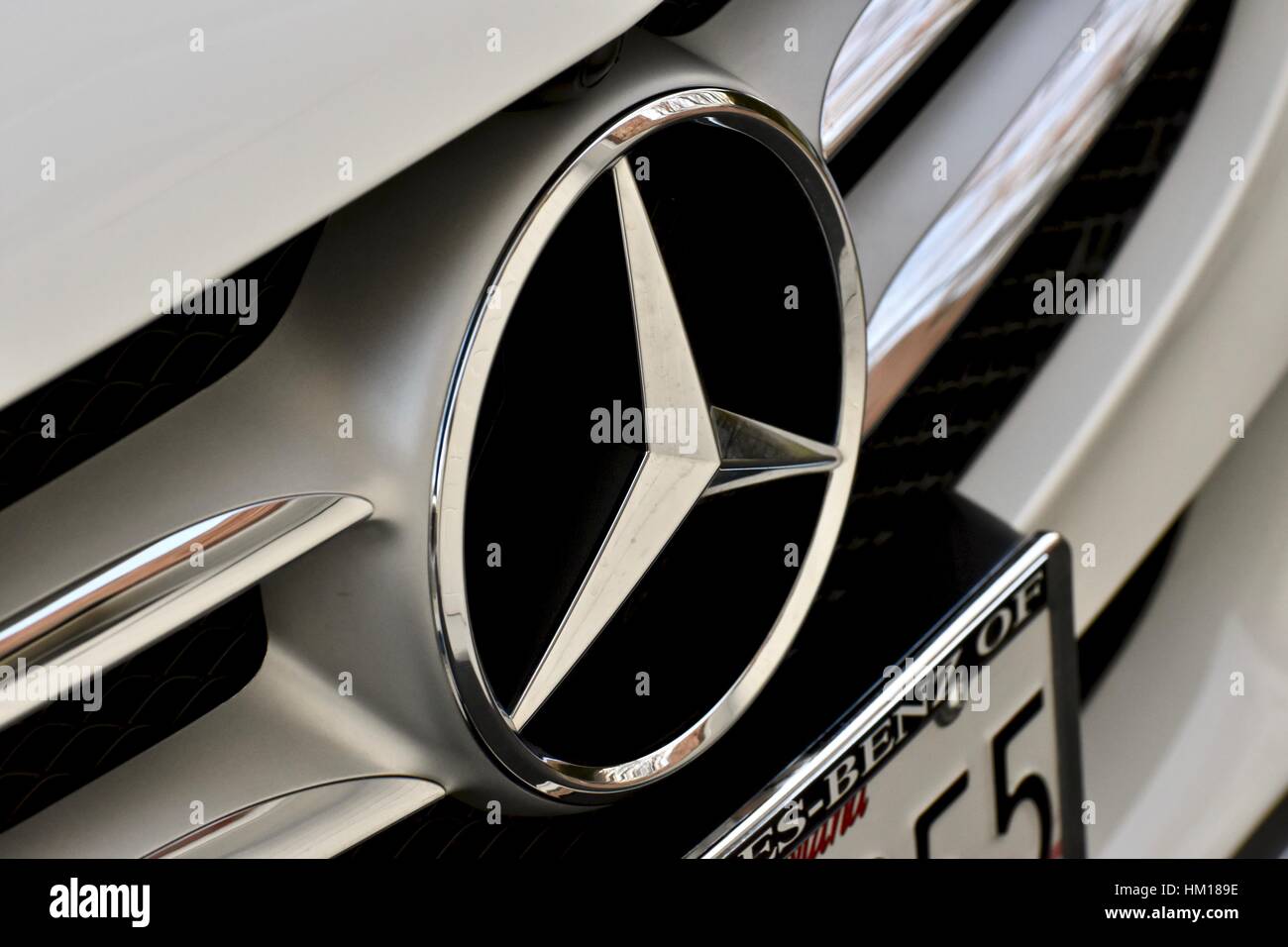A Mercedes Benz emblem on a white Mercedes Benz C-300 Stock Photo