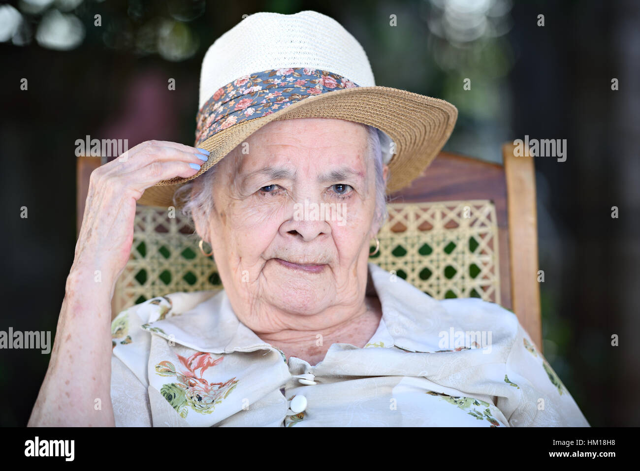portrait old grandma sitting in hat outdoors Stock Photo