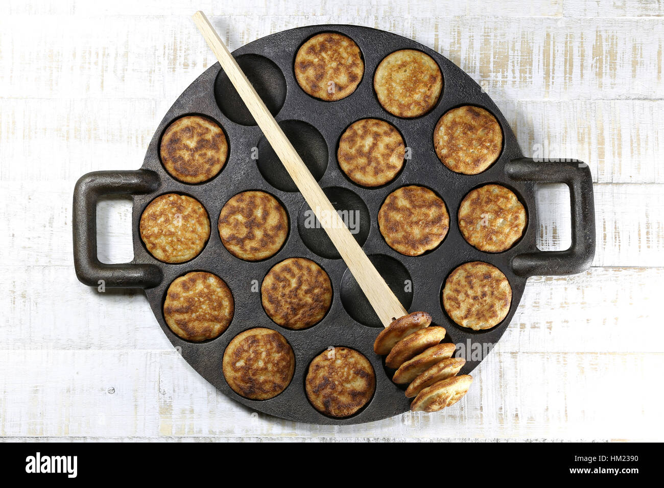 https://c8.alamy.com/comp/HM2390/homemade-dutch-poffertjes-in-a-traditional-cast-iron-pan-on-wooden-HM2390.jpg