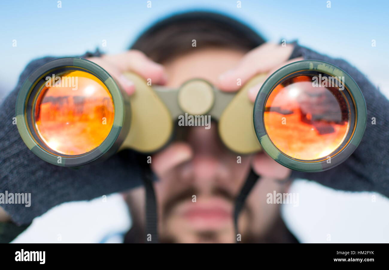 Man using binoculars outside on a winter day clsoe up Stock Photo