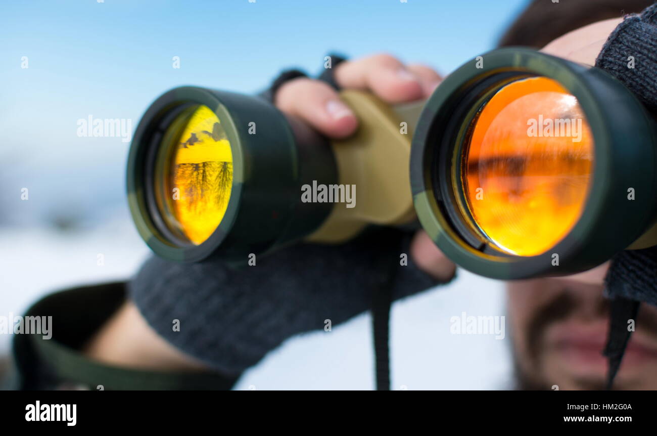 Man using binoculars outside on a winter day clsoe up Stock Photo