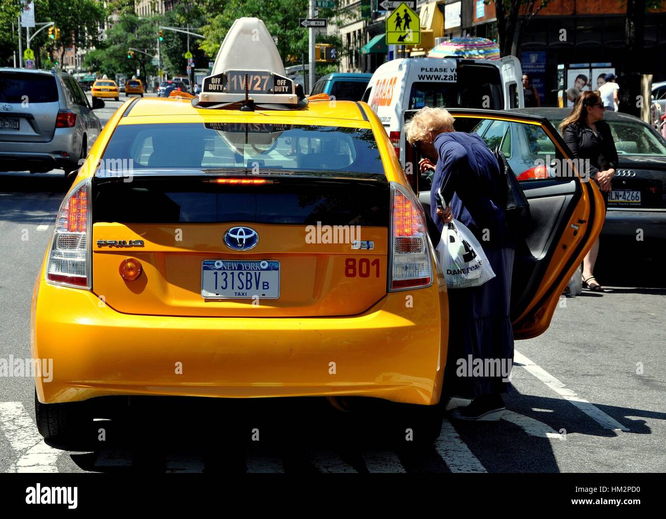 New York City - July 2, 2011:  Woman getting into a yellow taxicab at Broadway and West 80th Street Stock Photo