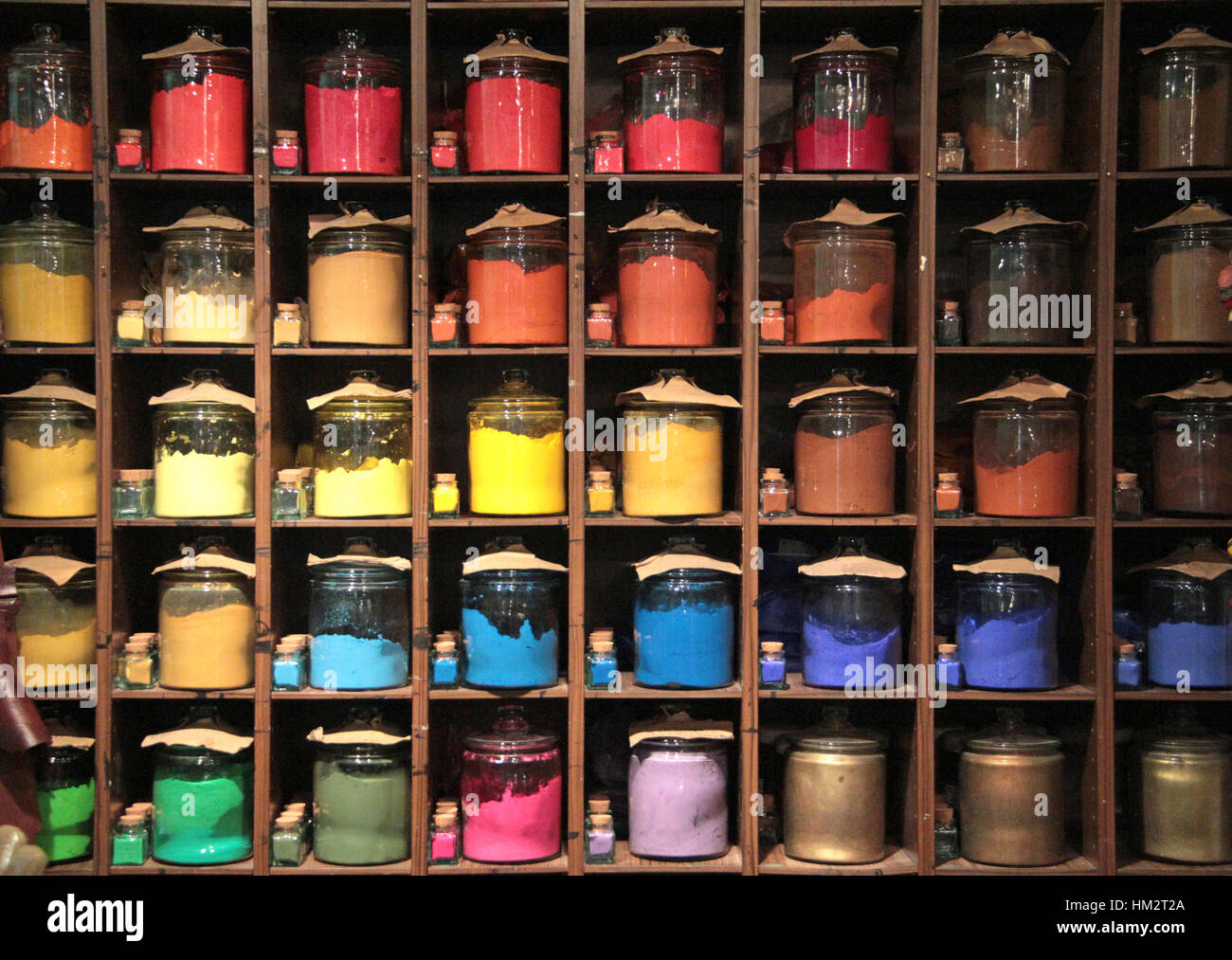 Various colorful dye in glass container on shelves in a paint shop for